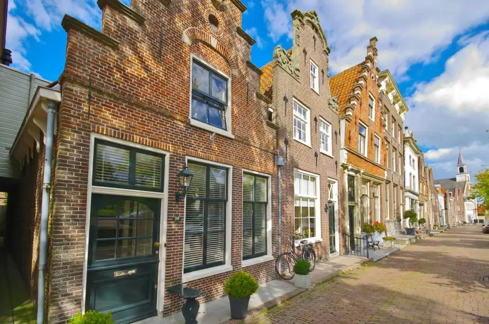 Bakstenen trapgevels en een smalle straat met fietsen in een Nederlandse binnenstad